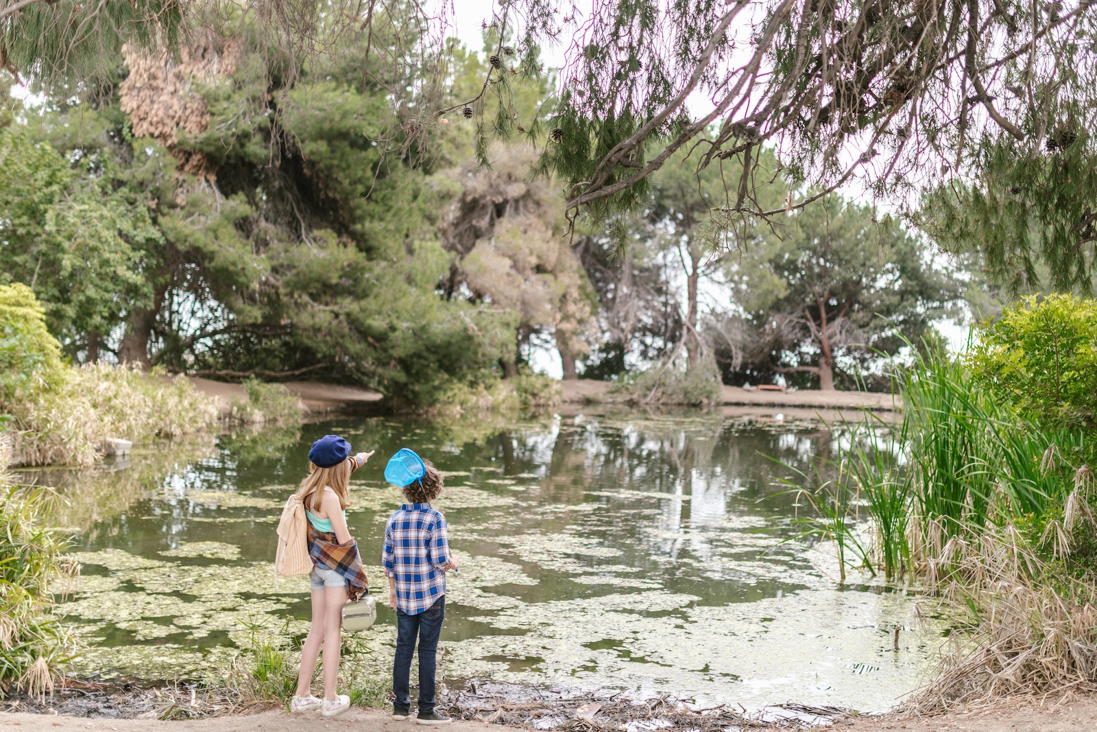 Girl and Boy Standing Near a Pond Looking at the View